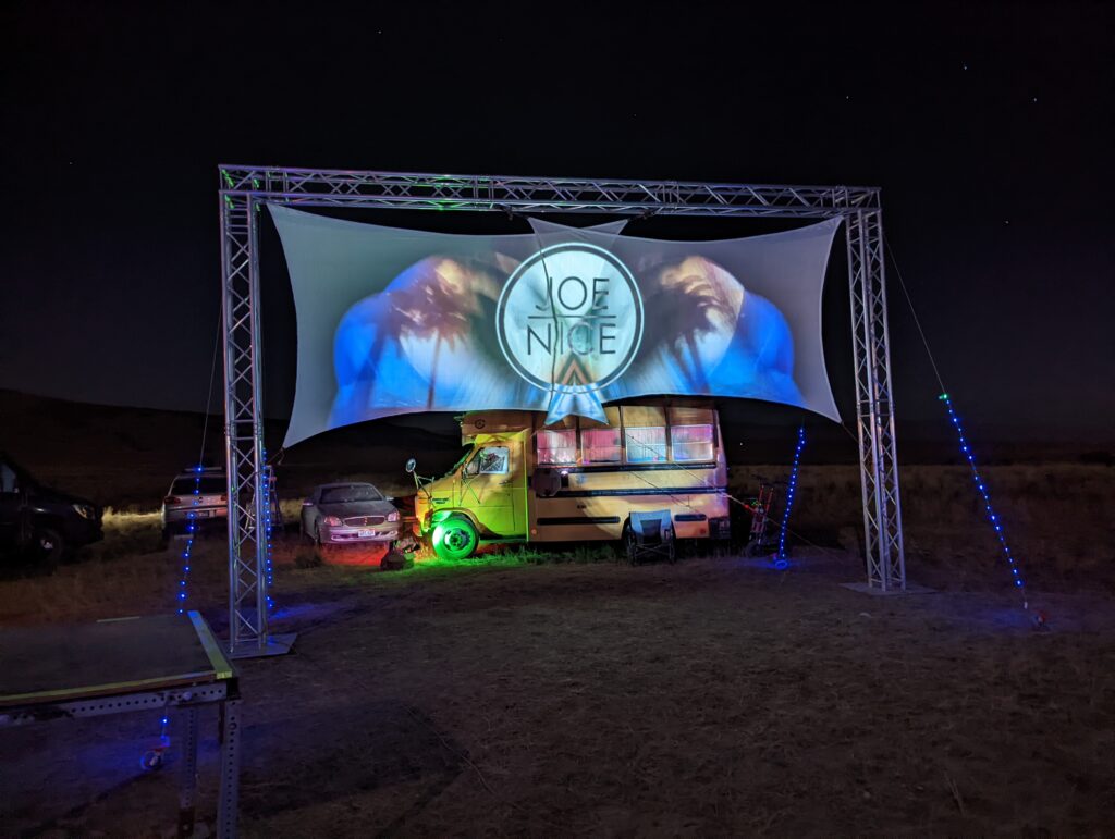 Desert campout shade structure and art car at night