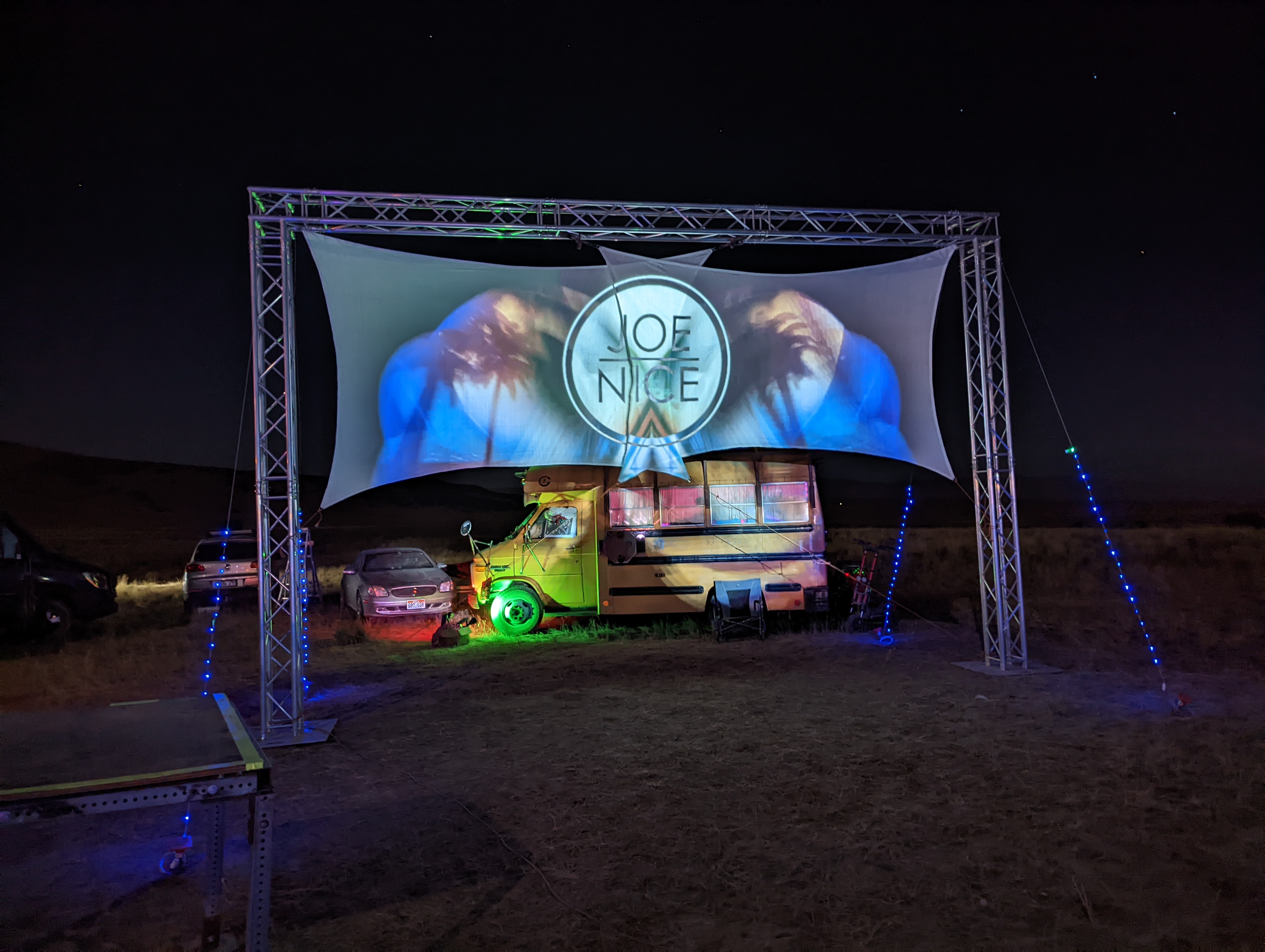 Desert campout shade structure and art car at night