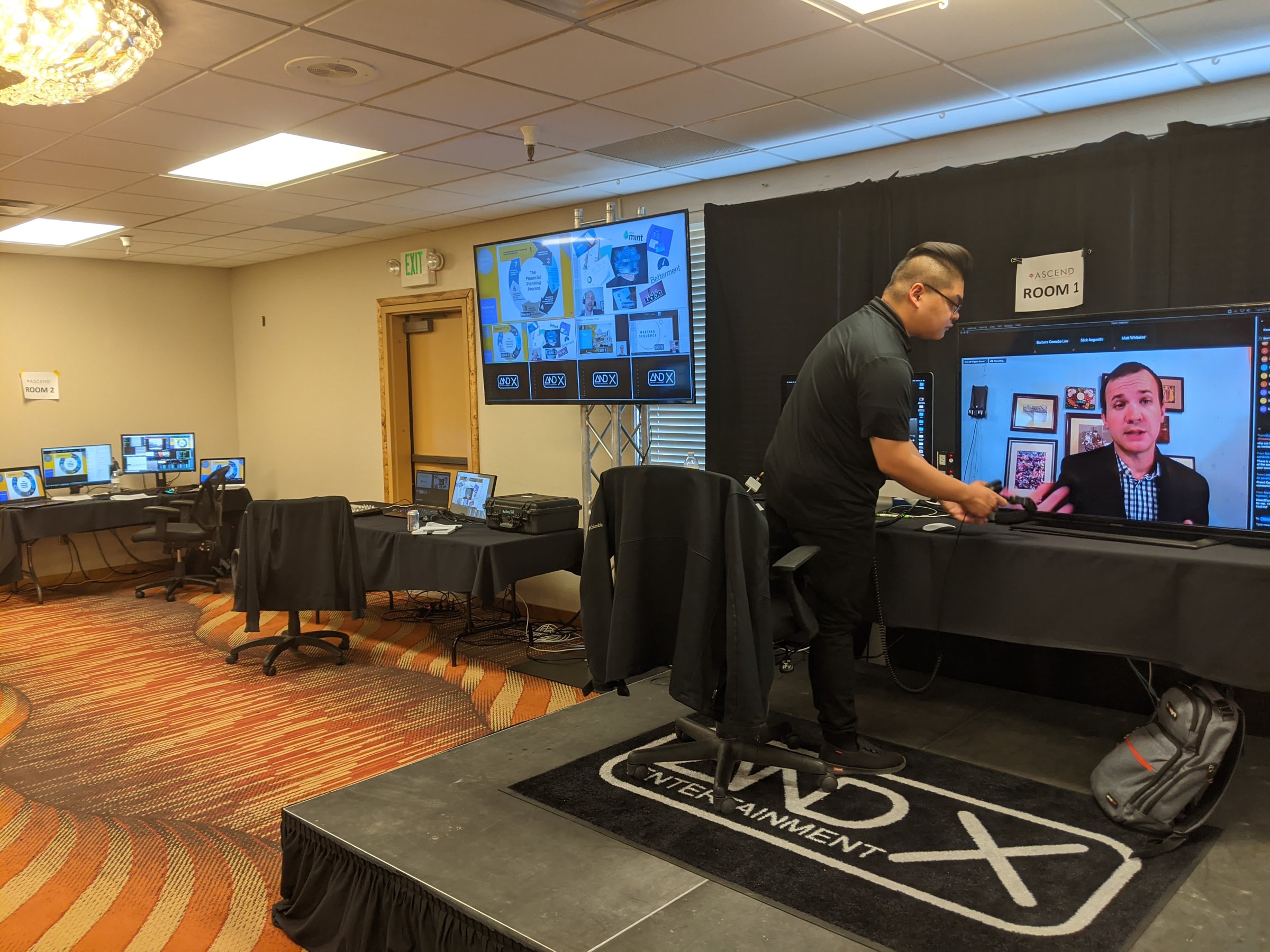 ANDX Entertainment livestream production in a hotel ballroom with a remote speaker on screen and multiple control stations