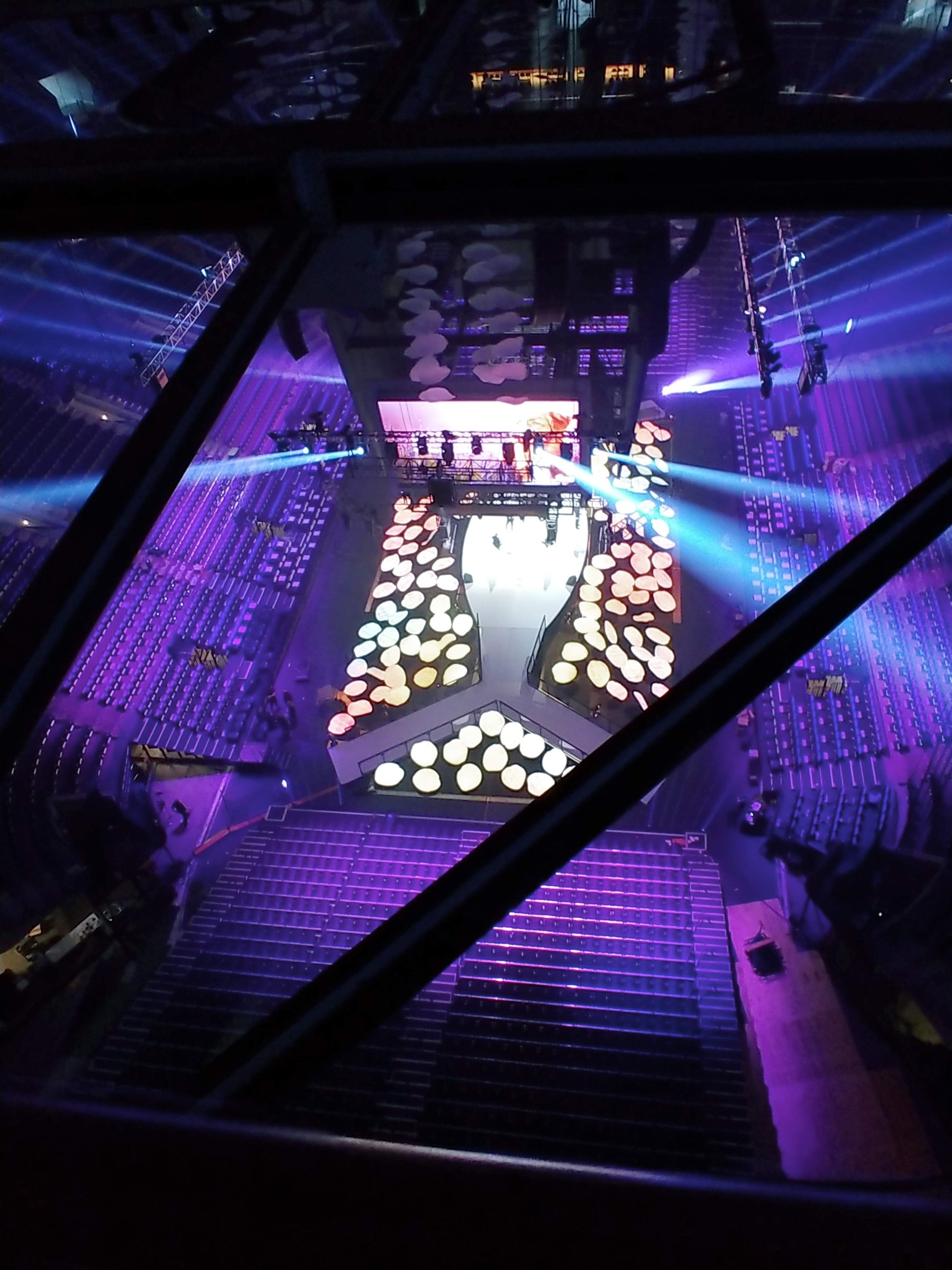 View from the projection booth over a purple-lit arena at Domopalooza with an illuminated disc floor set and LED stage