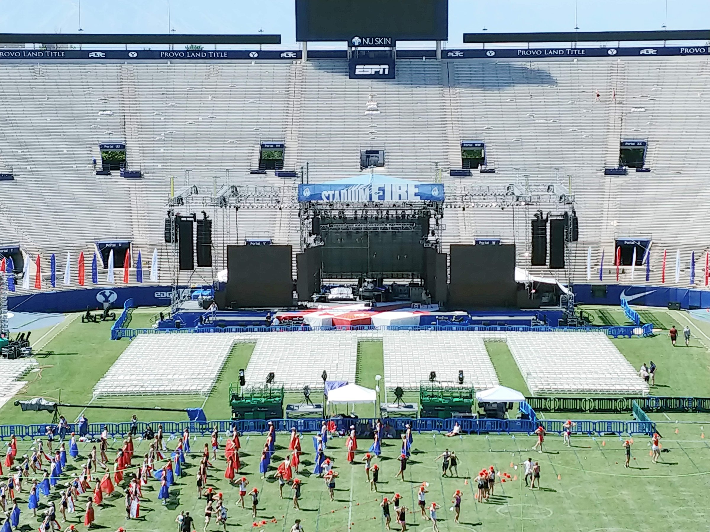 Stadium of Fire main stage at BYU stadium with performers rehearsing on the field during setup