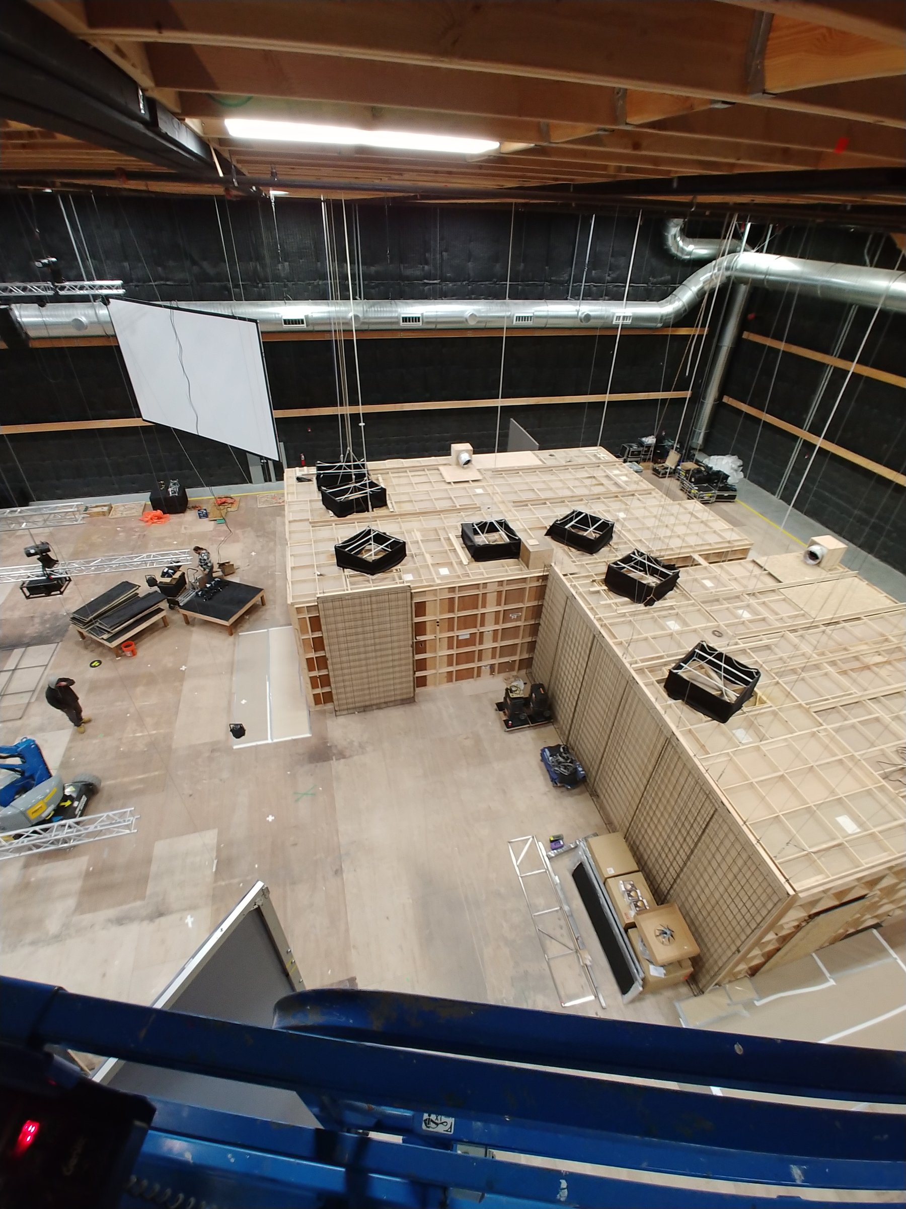 Set construction for a Yellowstone TV activation at Sundance, framed rooms and a projection screen seen from a lift
