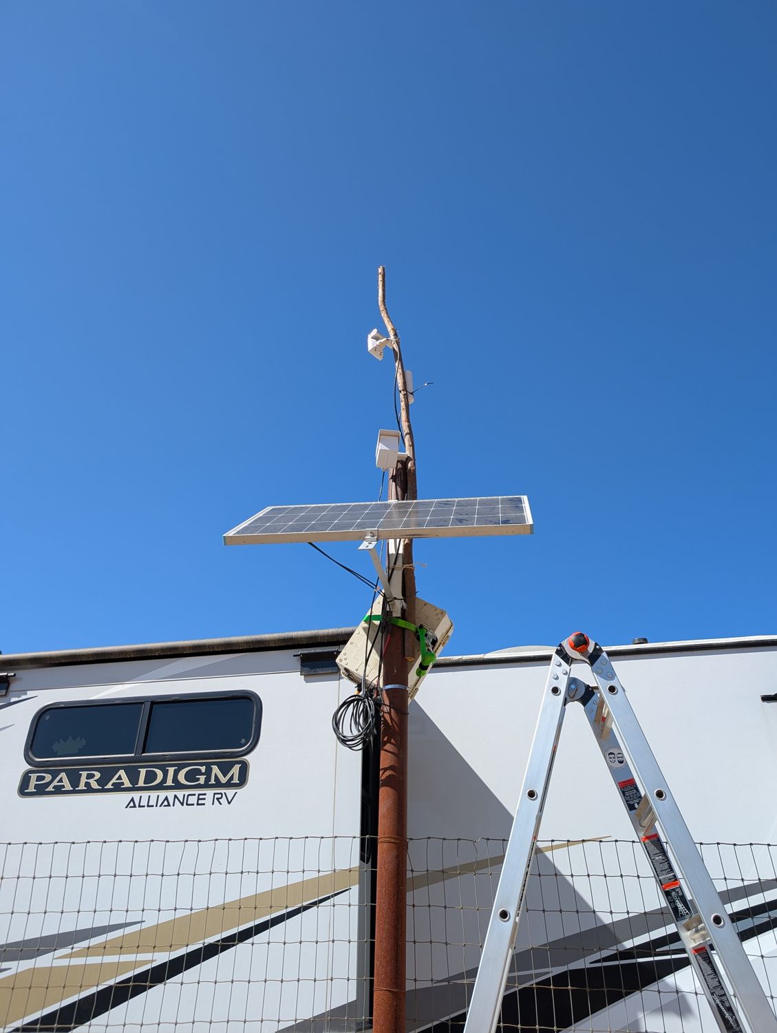 Field-improvised pole rig elevating a solar-powered access point